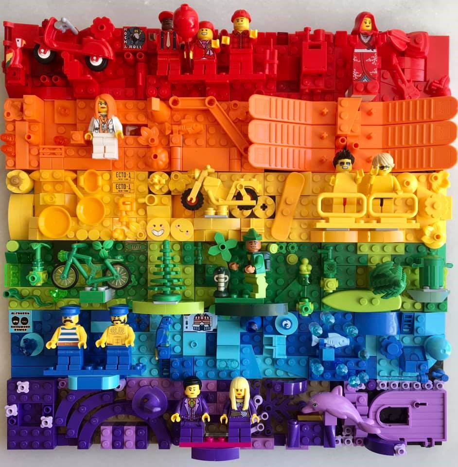 LEGO build of a Pride Flag with random parts used to detail the flag. Minifigure dot the flag.