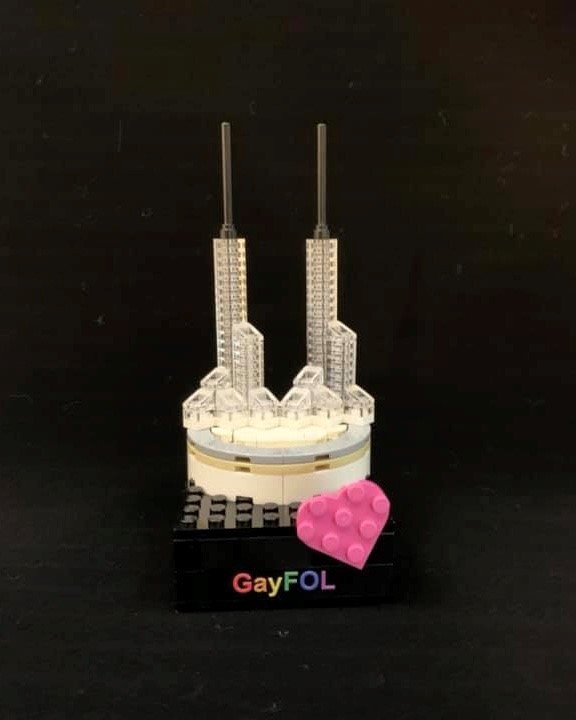 A LEGO build of the Oregon Convention Center, made from 1x1 LEGO plates stacked tall and 1x1 slopes at it's base, as well as a pink heart and GayFOL text.